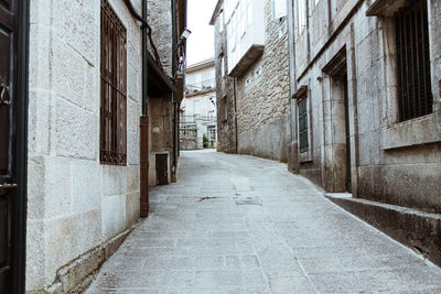 Empty alley amidst buildings in city