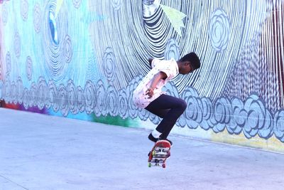 Full length of man skateboarding on road