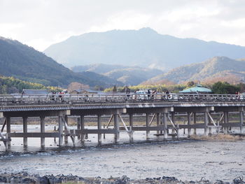 Bridge over river against cloudy sky