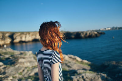 Rear view of woman looking at sea against sky