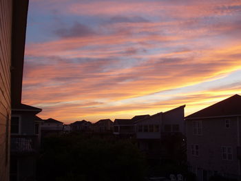 Buildings against cloudy sky at sunset