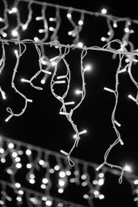 Close-up of illuminated lights hanging on metal
