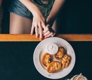 Midsection of woman preparing food in plate