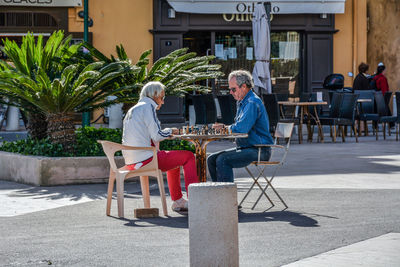 Side view of people sitting at sidewalk cafe