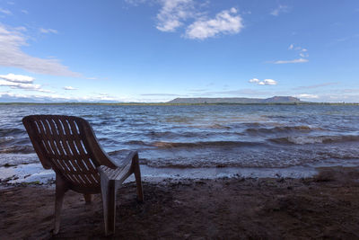 Chairs on beach against sky