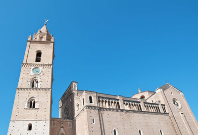 Low angle view of clock tower and chieti church building against clear blue sky