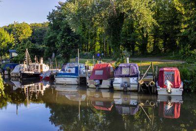 Boats moored on lake against trees