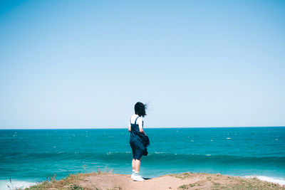 Full length of man on beach against clear sky