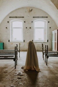 Little ghost standing in the abandoned house. autumn halloween