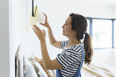 Side view of woman standing against wall