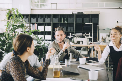 Creative business people discussing at table in office