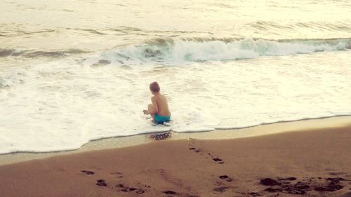 Rear view of boy on beach