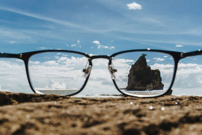 Close-up of eyeglasses on sunglasses at beach