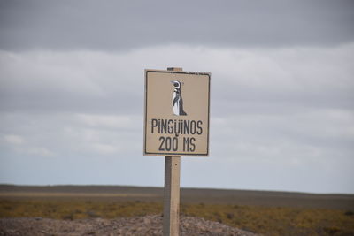 Close-up of road sign against sky