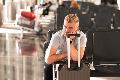 Man waiting in airport with baggage 