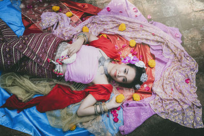 High angle view of woman in traditional clothing lying on footpath