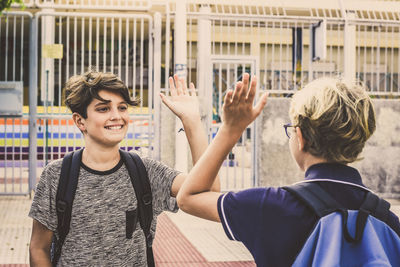 Smiling boy giving high-five to friend
