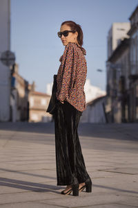 Portrait of young woman standing in city