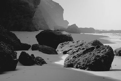 Rock formations by sea against sky