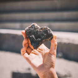 Cropped image of person holding heart shape stone