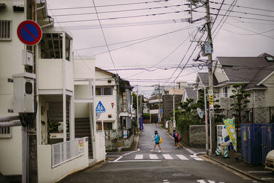 Man walking on road amidst buildings in city