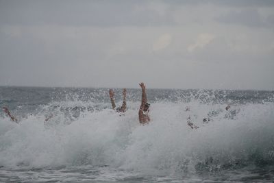 Man swimming in sea against sky