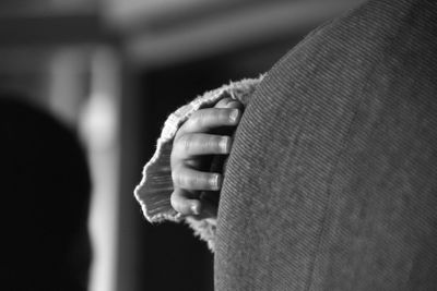 Close-up of child hand on sofa at home