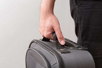 Close-up of man holding camera over white background