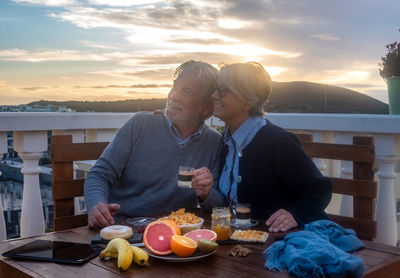 Senior couple enjoying food at sunset