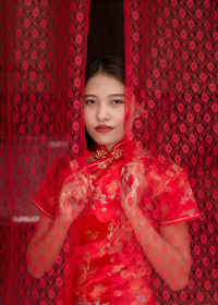 Portrait of smiling girl holding red indoors