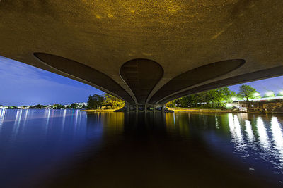 Underneath view of bridge over lake at dusk