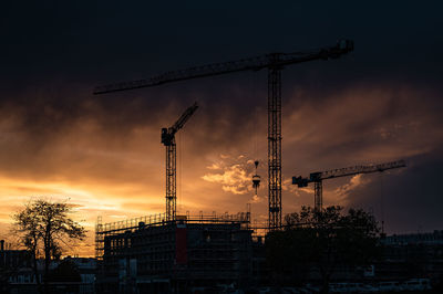 Cranes on a construction site at sunset