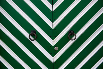 Ring knockers on green door