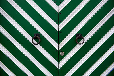 Ring knockers on green door
