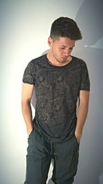 Portrait of young man standing against white background