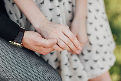 Midsection of couple holding hands