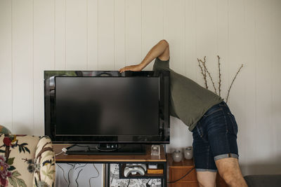 Man checking back of tv