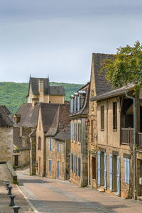 Old building by street against sky