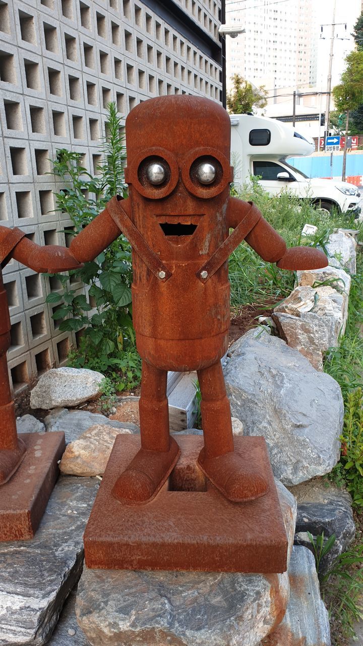 STATUE IN PARK AGAINST BUILDINGS