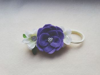 Close-up of purple flower on white table