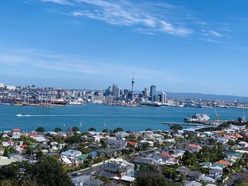 City at waterfront against blue sky