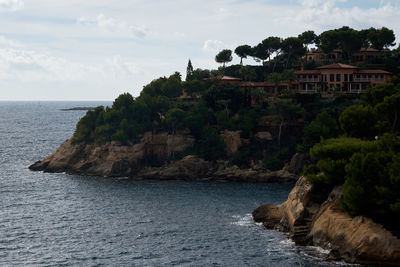 Scenic view of sea by buildings against sky