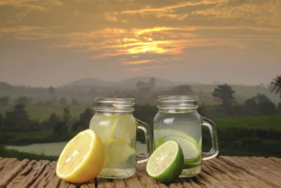 Close-up of drink on table against sky during sunset