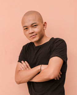 Portrait of young man standing against wall