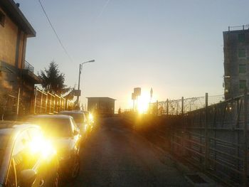 Street amidst buildings against sky during sunset