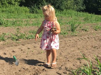 Full length of girl throwing trowel on field