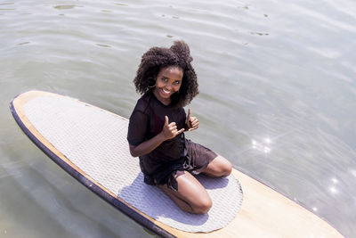 Portrait of smiling young woman sitting in water