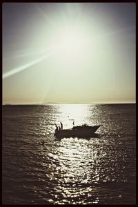 Boat sailing in sea at sunset
