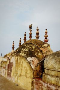 Low angle view of cross on building against sky