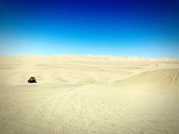 Scenic view of desert against clear blue sky